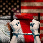 The empathy response - hands raised in cuffs before two national flags